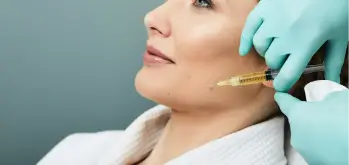 Woman receiving Platelet-Rich Plasma Therapy (PRP) on her jawline
